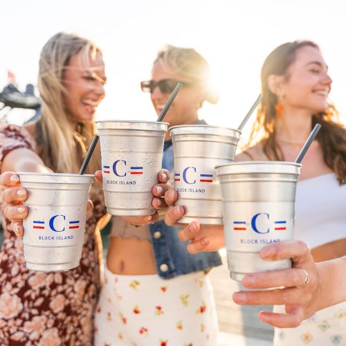 A group of people are holding metal cups with straws, featuring a logo and the text 